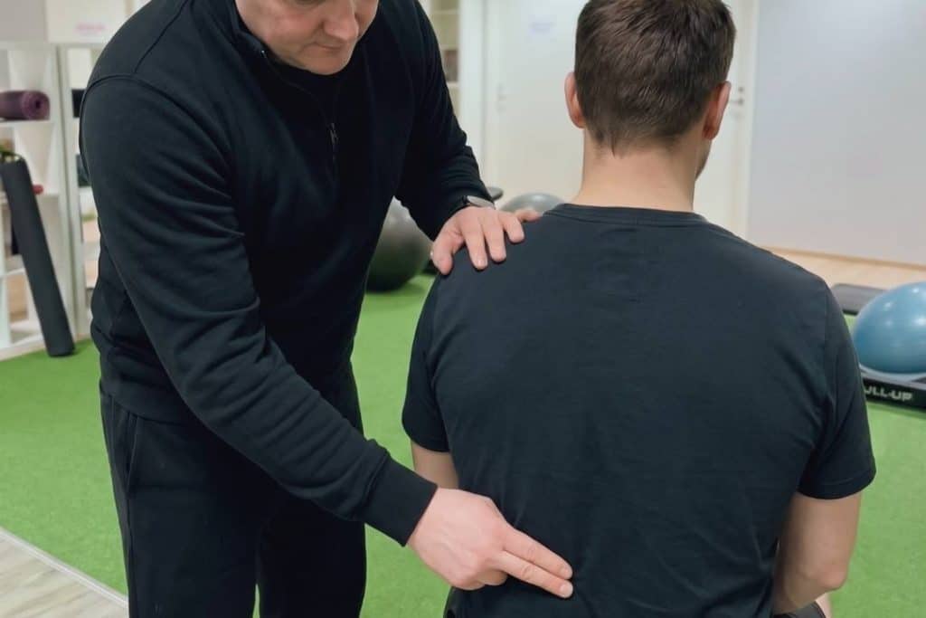 Fysioterapeutti tutkii asiakkaan alaselkää Fit Lahden harjoitusalueella.